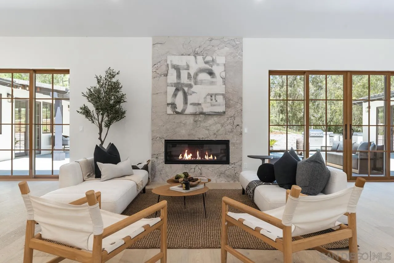 15245 El Camino Real Rancho Santa Fe, CA 92067 - Photo 5 of 41 a living room with furniture large window and fireplace
