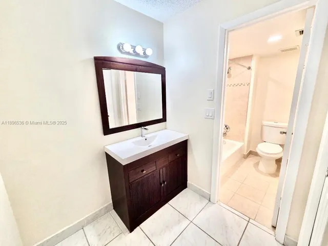 a bathroom with a sink a toilet and mirror