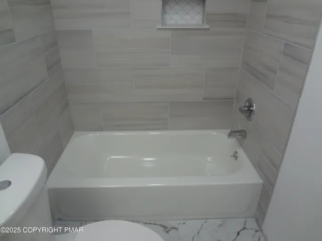 a bathroom with a bathtub and toilet
