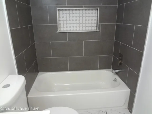 a white bath tub sitting next to a white toilet
