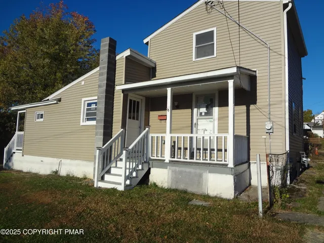 a view of a house with a small yard and wooden fence