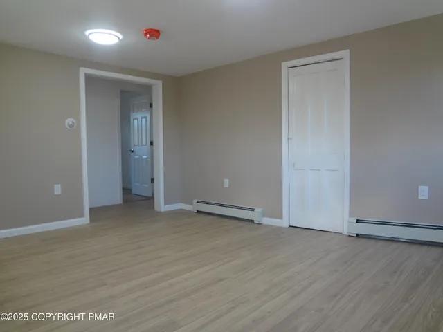 an empty room with wooden floor and closet