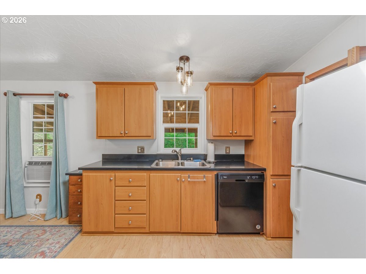 475 East 9th Street Rainier, OR 97048 - Photo 12 of 43 a kitchen with granite countertop a sink stainless steel appliances and cabinets