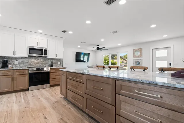 a large kitchen with granite countertop lots of counter space a sink and appliances