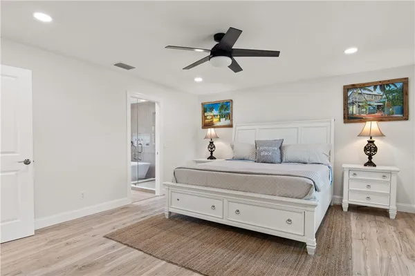 a spacious bedroom with a bed and a ceiling fan