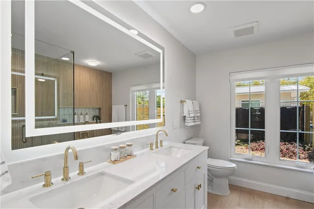 a bathroom with a granite countertop sink mirror and a bathtub