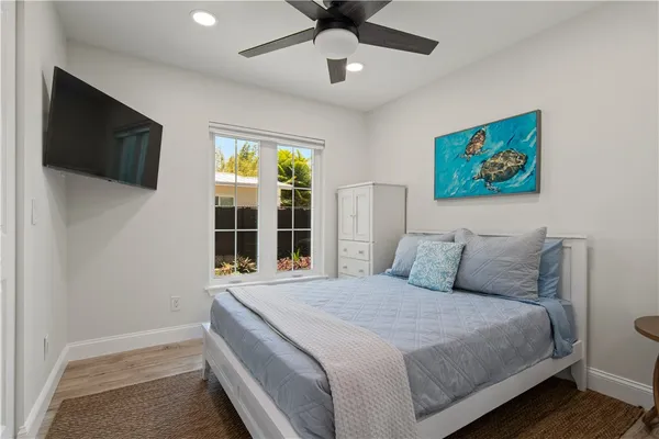 a bedroom with a large bed and a flat tv screen on dresser