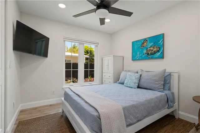 a bedroom with a large bed and a flat tv screen on dresser