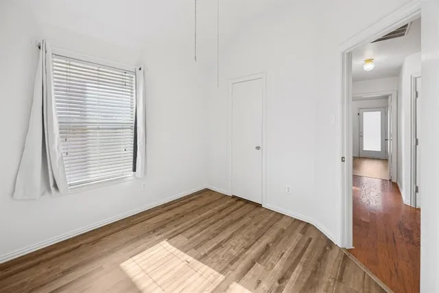 a view of a room with wooden floor and a window