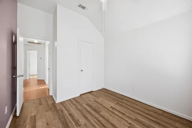 a view of a room with wooden floor and a hallway