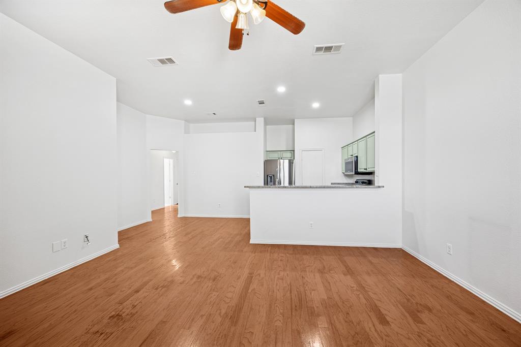 1747 Preston On The Lake Boulevard Little Elm, TX 75068 - Photo 6 of 23 a view of kitchen and empty room with wooden floor