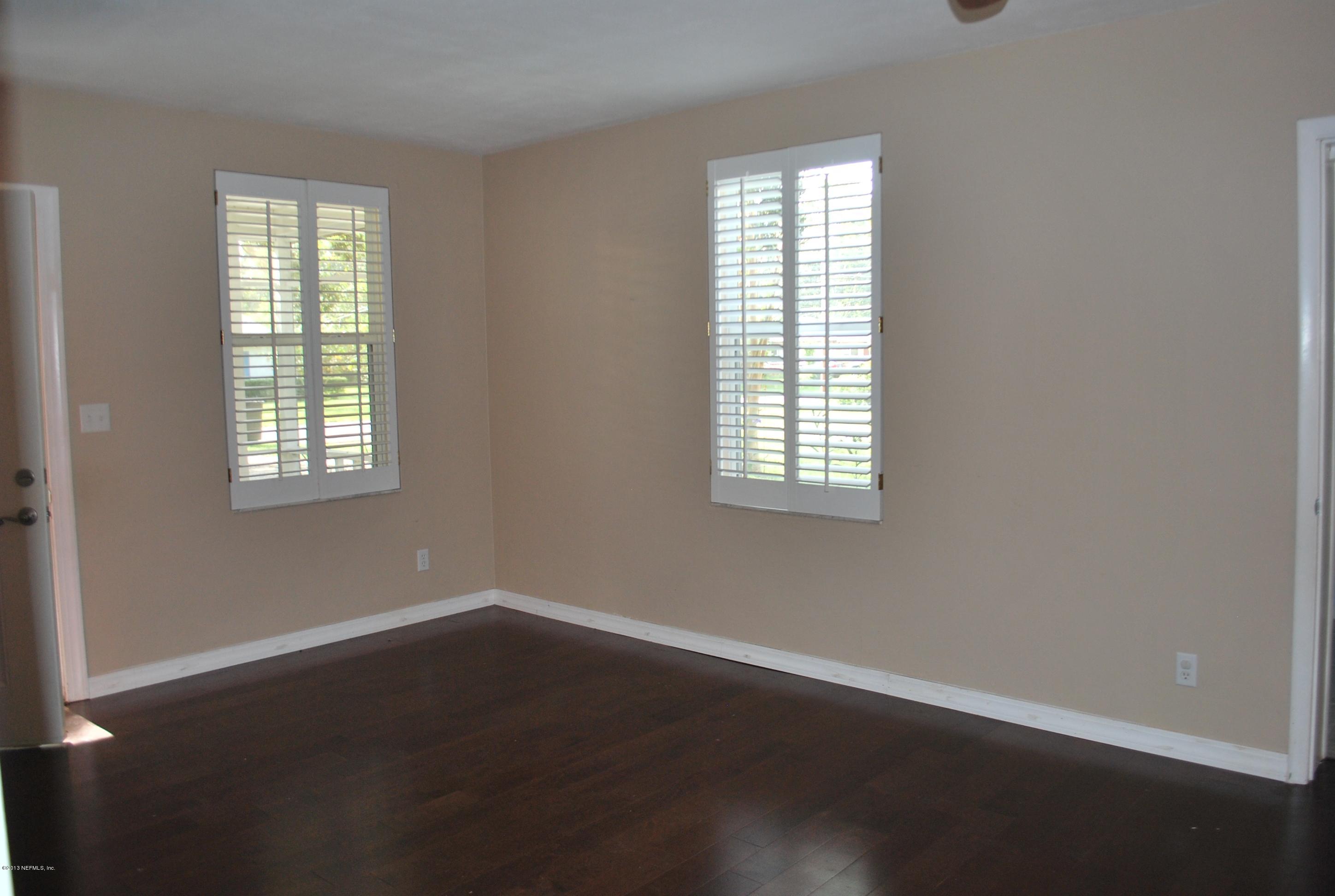 3917 Jean Street Jacksonville, FL 32205 - Photo 3 of 19 an empty room with wooden floor and windows