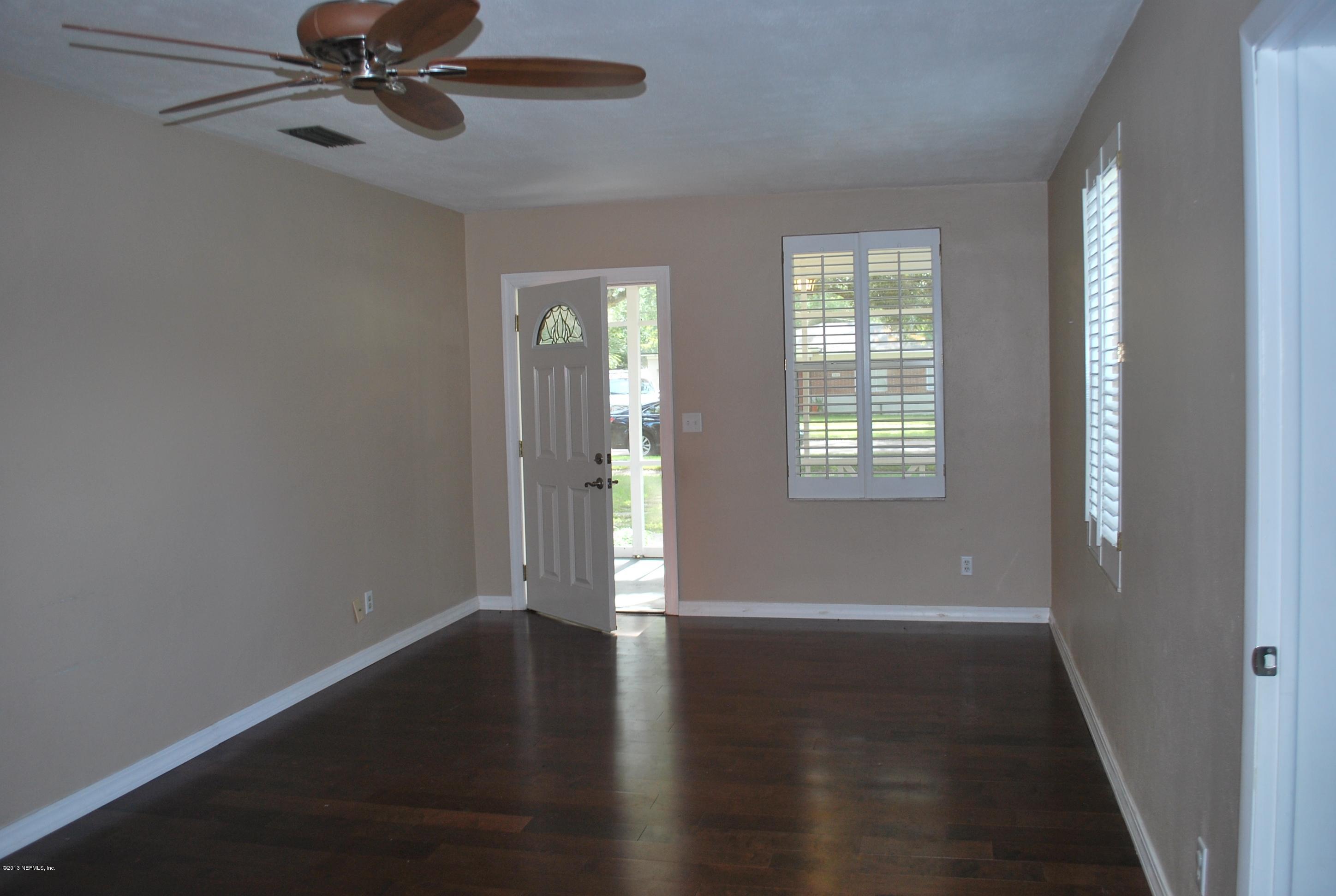 3917 Jean Street Jacksonville, FL 32205 - Photo 4 of 19 an empty room with wooden floor fan and windows