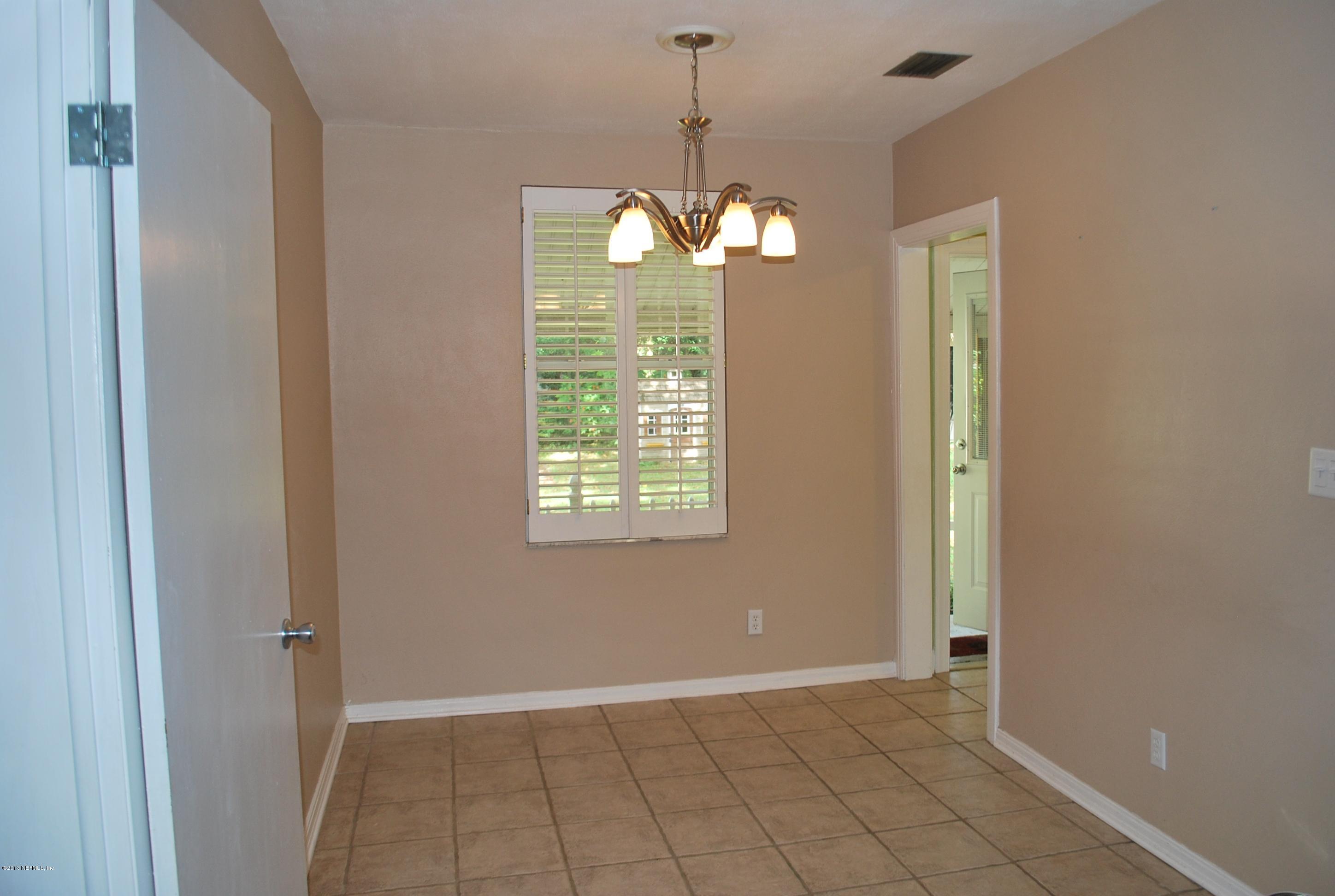 3917 Jean Street Jacksonville, FL 32205 - Photo 6 of 19 a view of an empty room with window chandelier fan and fire place