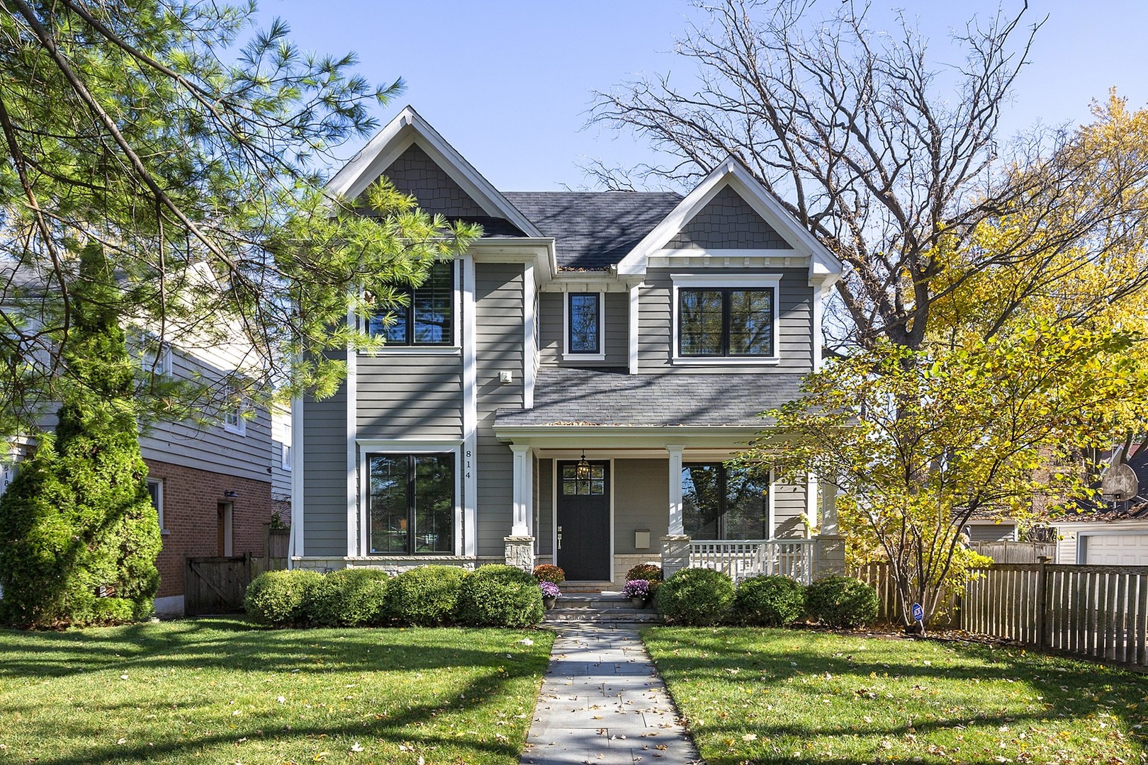 a front view of a house with a yard and trees