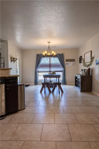 a dining room with kitchen island granite countertop a table chairs and a refrigerator