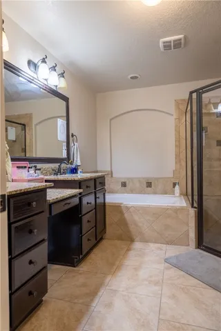 a spacious bathroom with a granite countertop sink a mirror and a bathtub