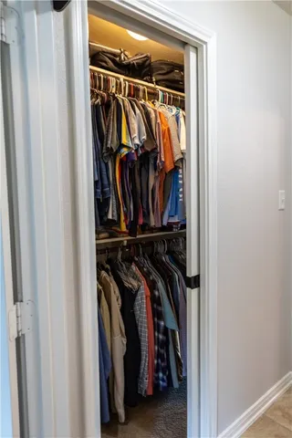 a view of walk in closet with clothes and shoes