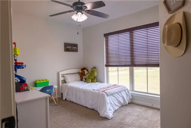 a bedroom with a bed a chandelier and a window