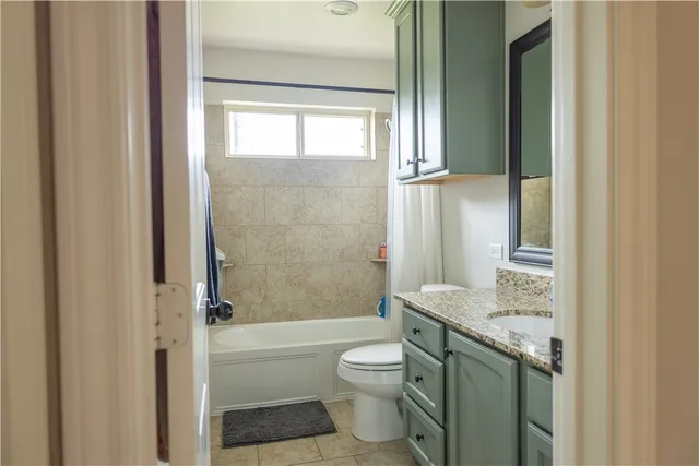 a bathroom with a granite countertop toilet a sink and a bathtub