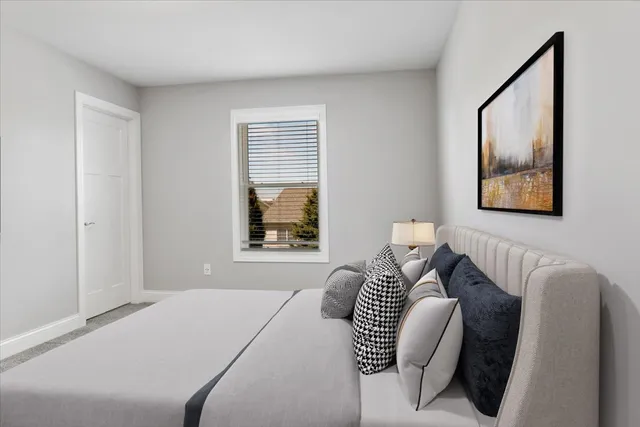 a bedroom with a bed and a painting on the wall