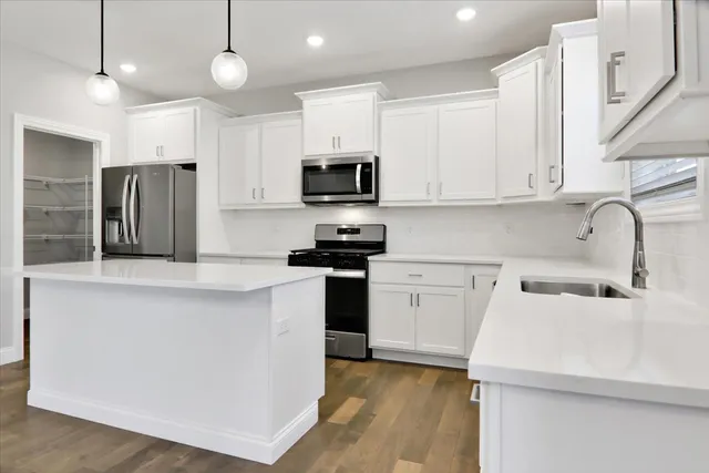 a kitchen with a sink a stove a refrigerator and cabinets