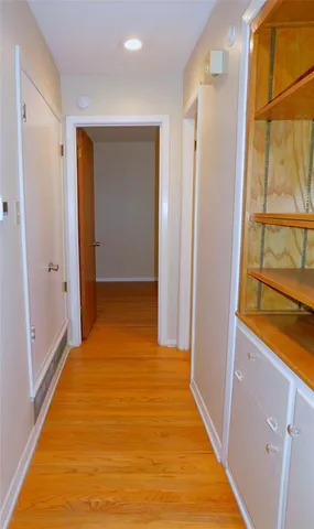 a view of a hallway with wooden floor and doors