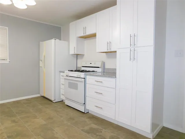 a kitchen with cabinets appliances a sink and a refrigerator