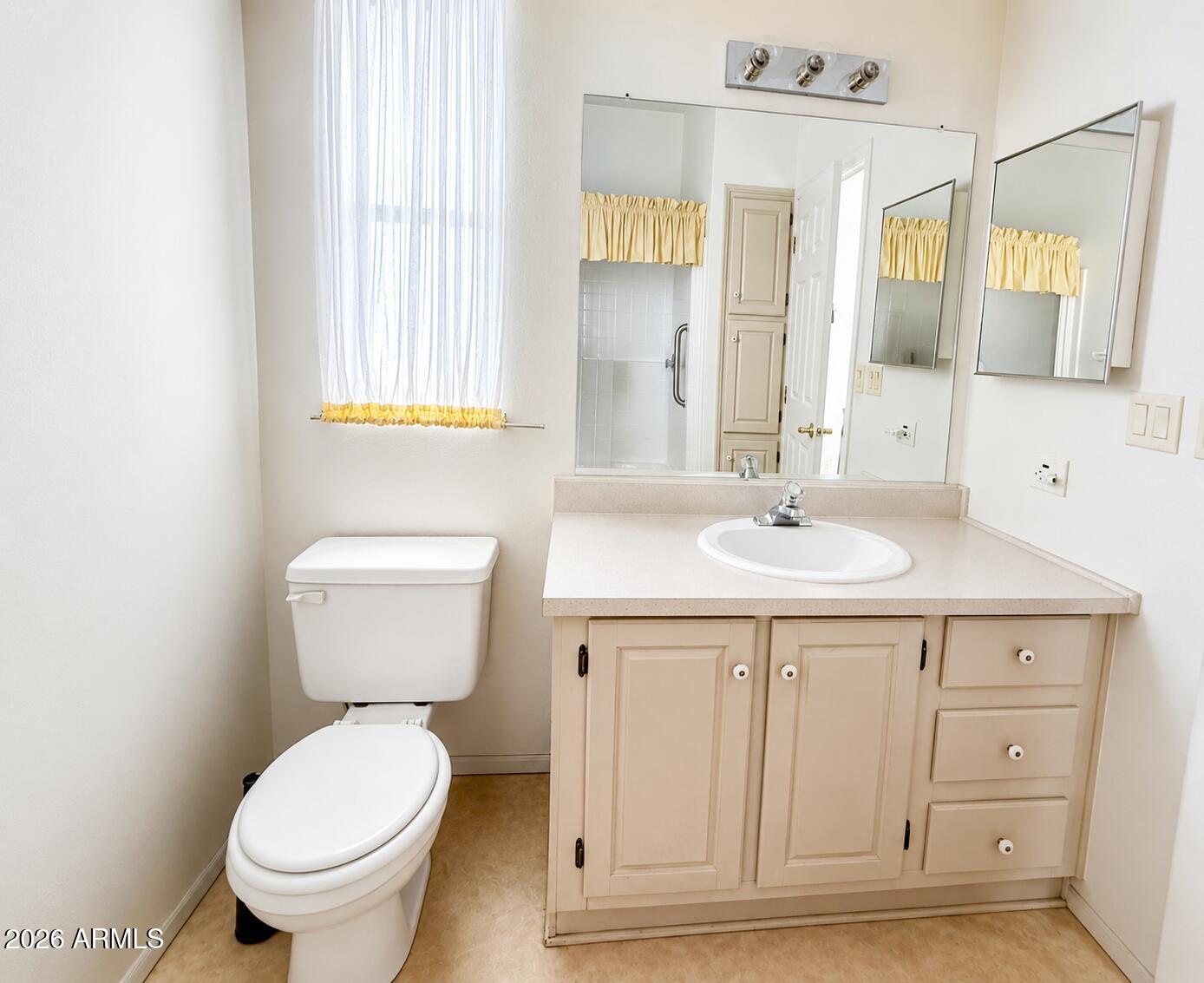 8865 East Baseline Road, Unit 103 Mesa, AZ 85209 - Photo 20 of 47 a bathroom with a sink a toilet and a mirror