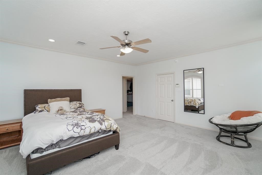 4406 Feagan Street, Unit A Houston, TX 77007 - Photo 19 of 29 a bedroom with a bed and a chandelier