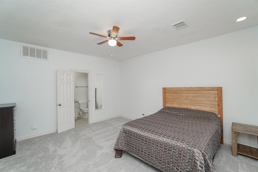 4406 Feagan Street, Unit A Houston, TX 77007 - Photo 24 of 29 a bedroom with a bed and a ceiling fan