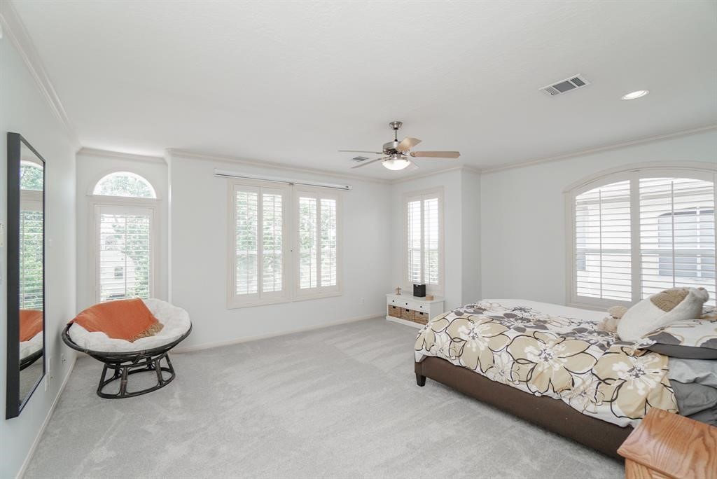 4406 Feagan Street, Unit A Houston, TX 77007 - Photo 27 of 29 a spacious bedroom with a bed and a chandelier