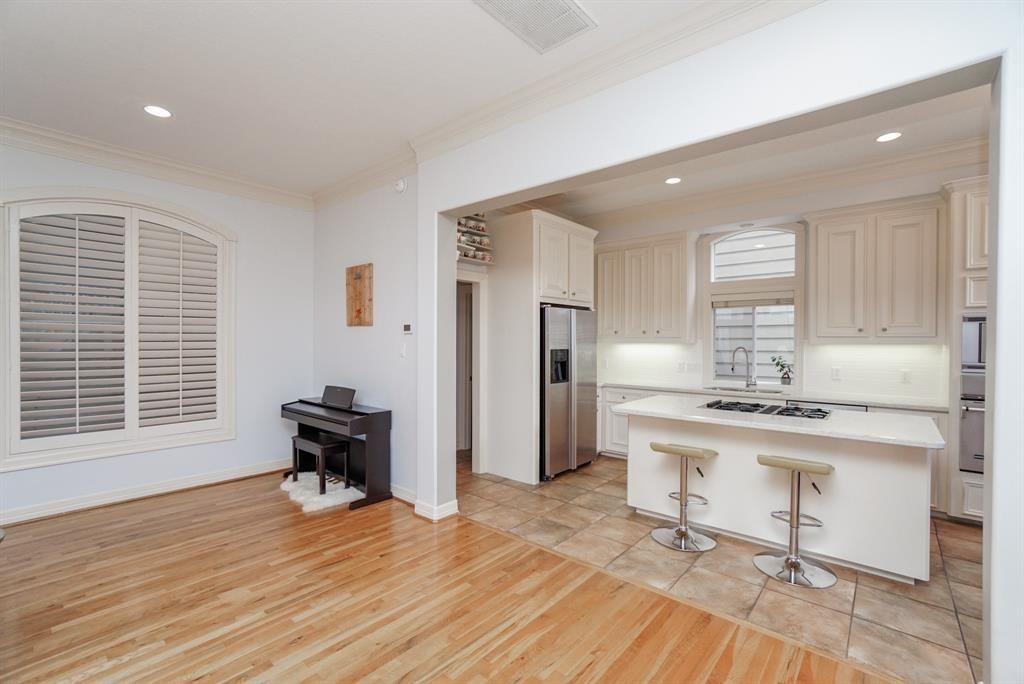 4406 Feagan Street, Unit A Houston, TX 77007 - Photo 7 of 29 a kitchen with stainless steel appliances kitchen island hardwood floor stove sink a table and chairs in it