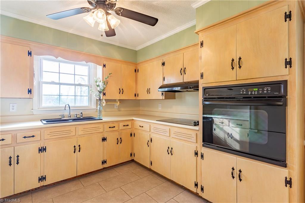 5104 Mockingbird Road Greensboro, NC 27406 - Photo 10 of 25 Don't miss the bright kitchen, with new tile flooring, composite-type sink, separate cooktop and large wall oven! You will love cooking and spending time in your home with family and friends!