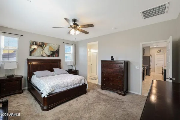a spacious bedroom with a bed and a dresser