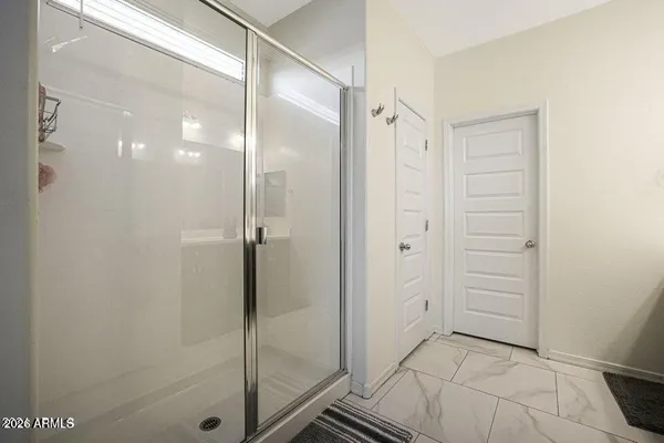 a bathroom with a shower and a glass door
