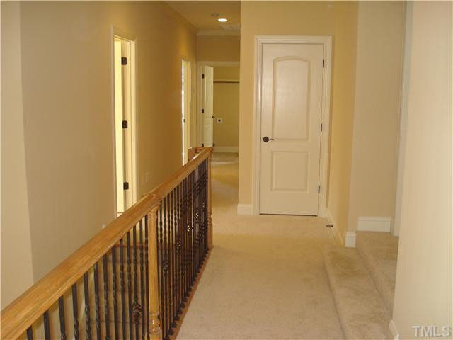 7021 Rippling Stone Lane Raleigh, NC 27612 - Photo 16 of 25 a view of a hallway with wooden floor