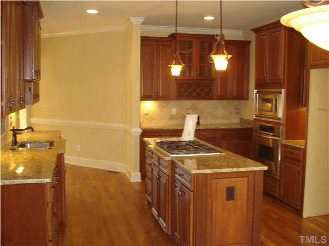 7021 Rippling Stone Lane Raleigh, NC 27612 - Photo 8 of 25 a kitchen that has a sink a stove and a microwave oven