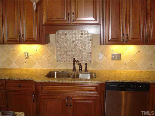 7021 Rippling Stone Lane Raleigh, NC 27612 - Photo 9 of 25 a sink with granite countertop white cabinets and a granite counter top