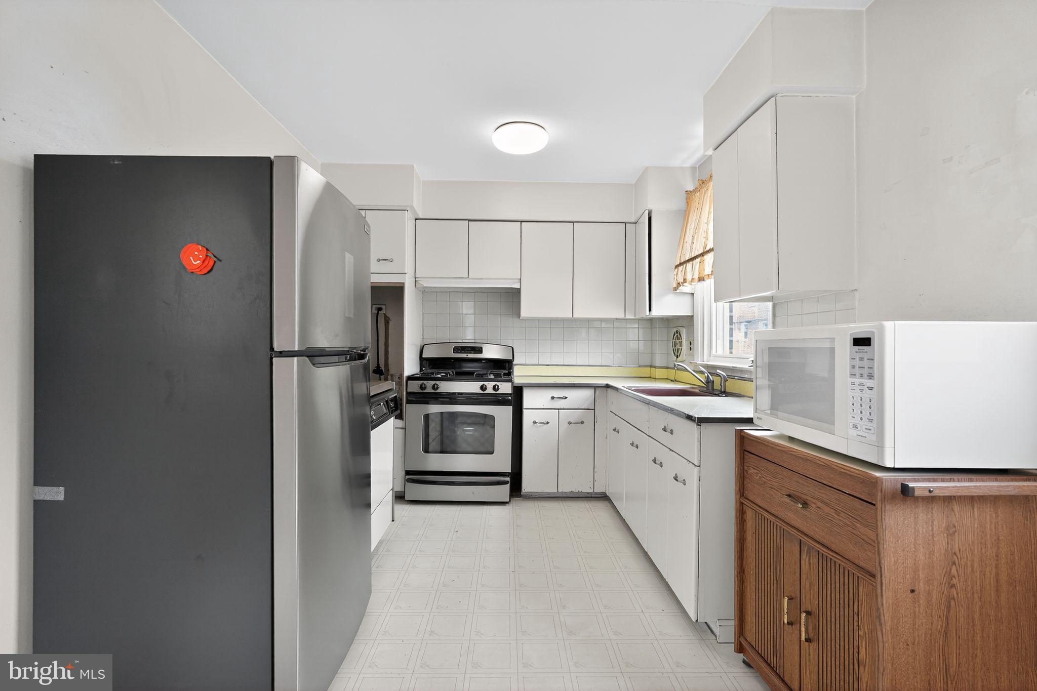 1711 Kendrick Street Philadelphia, PA 19152 - Photo 10 of 29 a kitchen with cabinets and white stainless steel appliances
