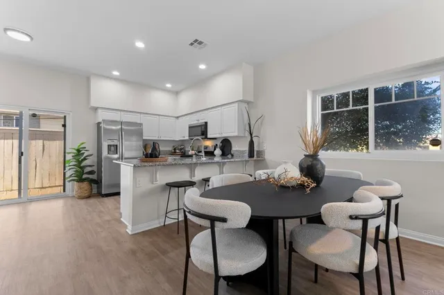 a kitchen with white cabinets and chairs