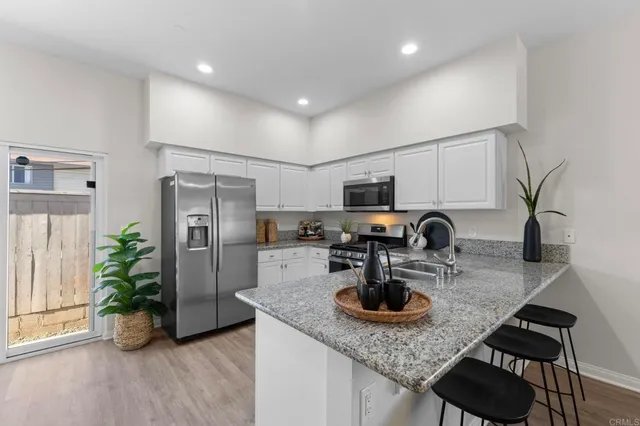 a kitchen with a refrigerator a stove a sink and a granite counter tops