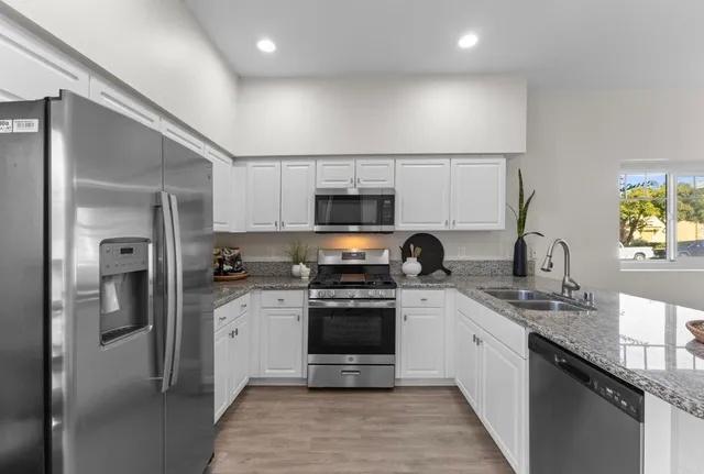 a kitchen with stainless steel appliances a stove sink and refrigerator