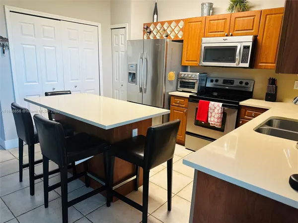 a kitchen with stainless steel appliances kitchen island granite countertop a dining table and chairs