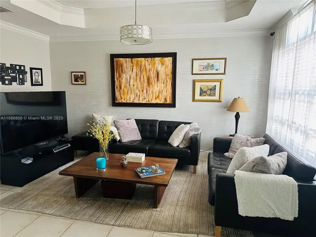 a living room with furniture a chandelier and a window