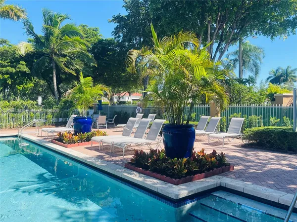 a view of a patio with table and chairs potted plants and palm tree