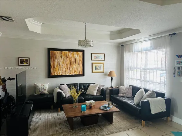 a living room with furniture a large window and a chandelier