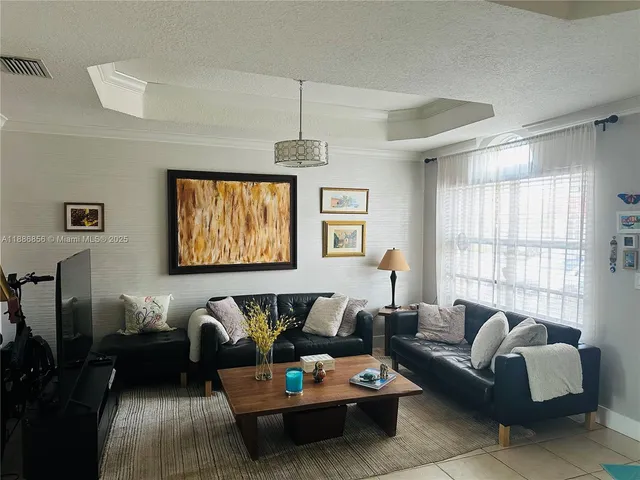 a living room with furniture a large window and a chandelier