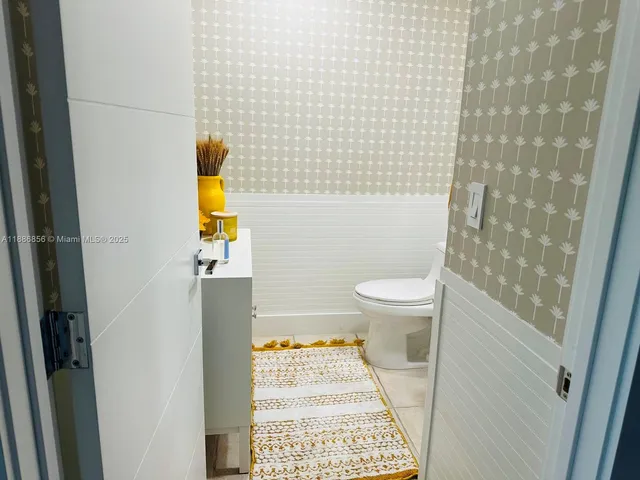 a bathroom with a toilet and a shower curtain