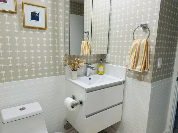 a bathroom with a sink a toilet and a mirror